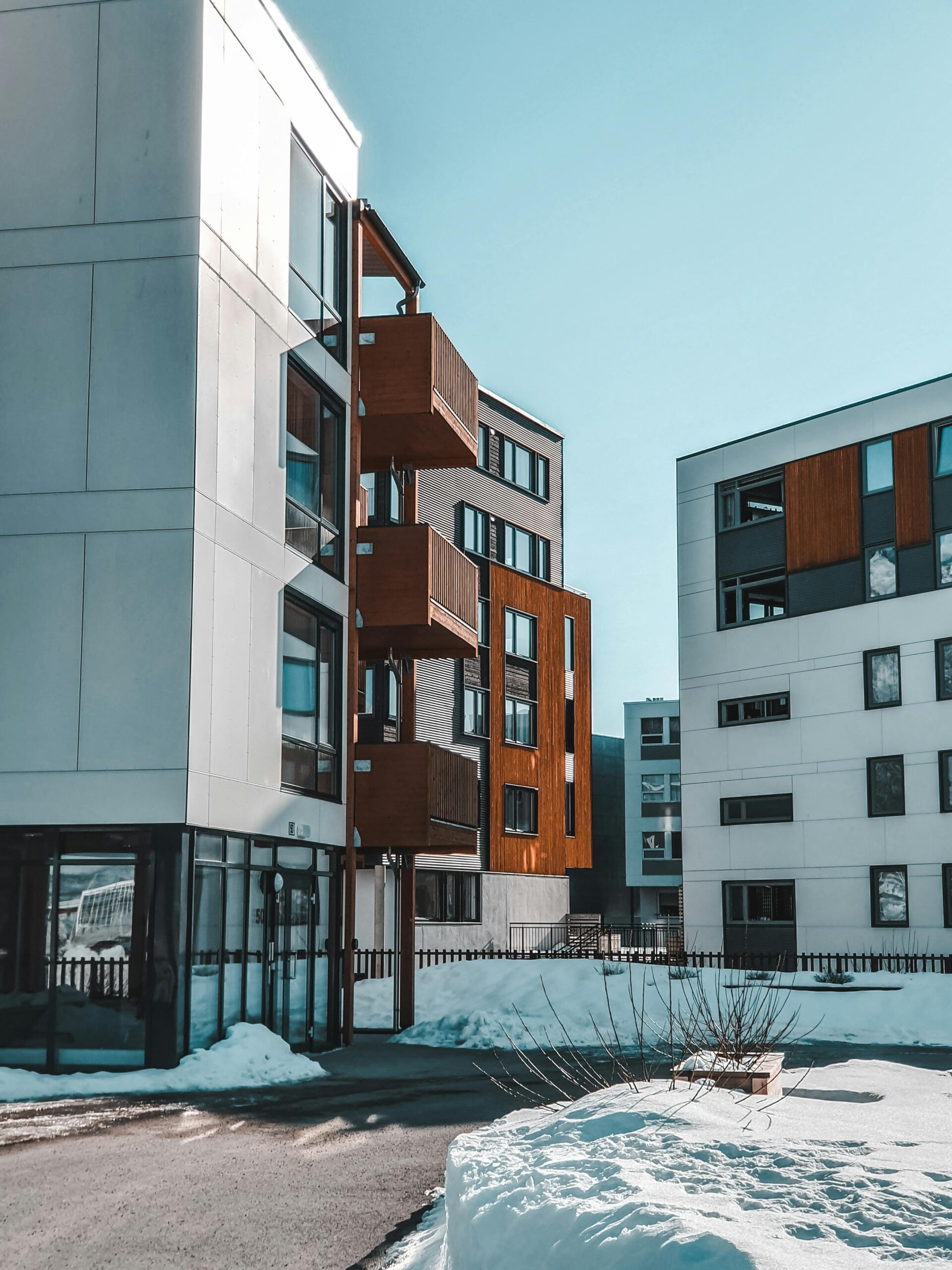 Smart Vara Contemporary apartment buildings with wooden accents in a snowy urban environment.
