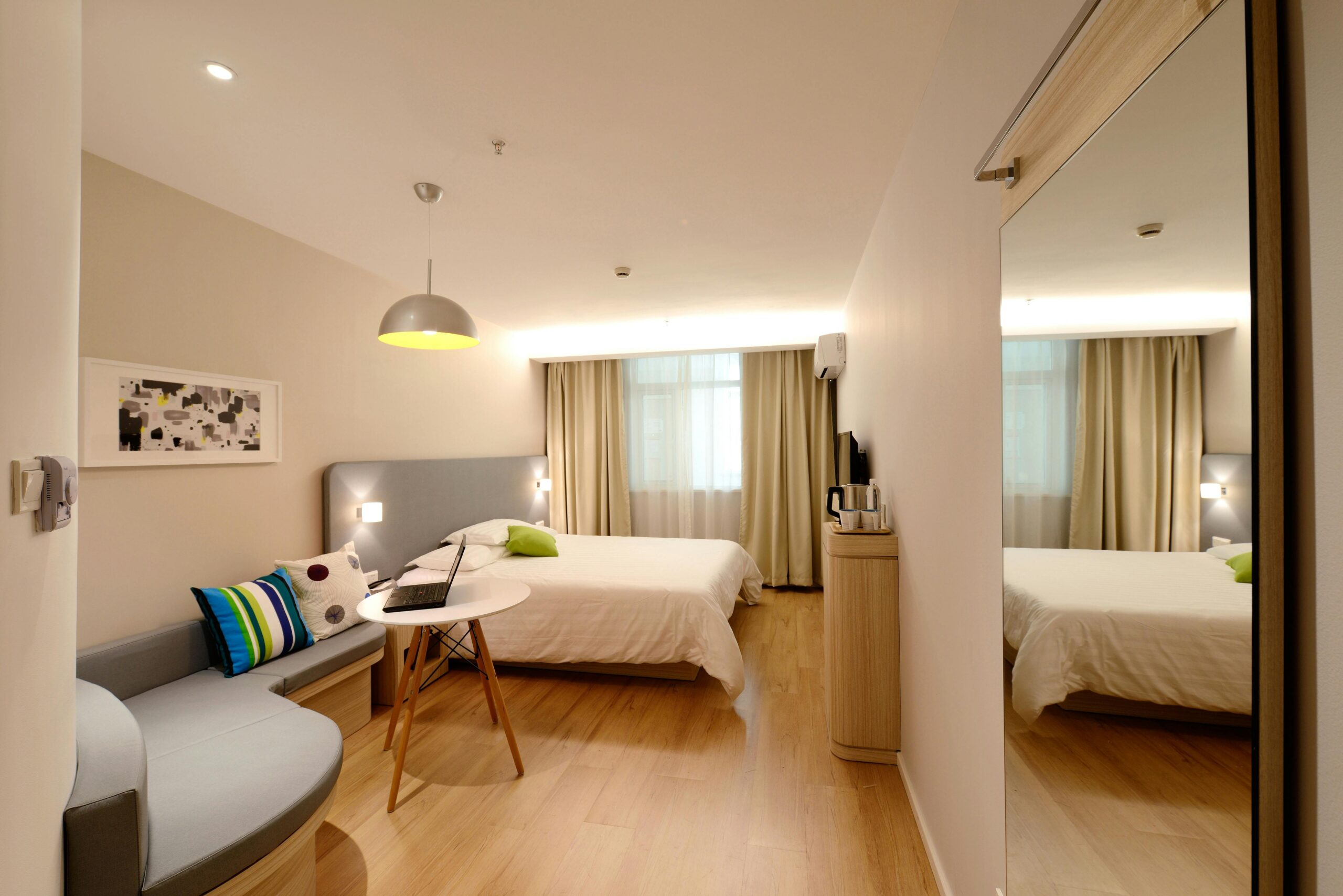 Elanikuke Spacious modern hotel room featuring cozy decor and neutral tones with natural light.